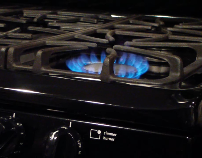 a gas stove with a burner lit