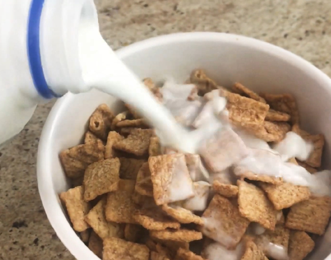 Milk being poured on cereal
