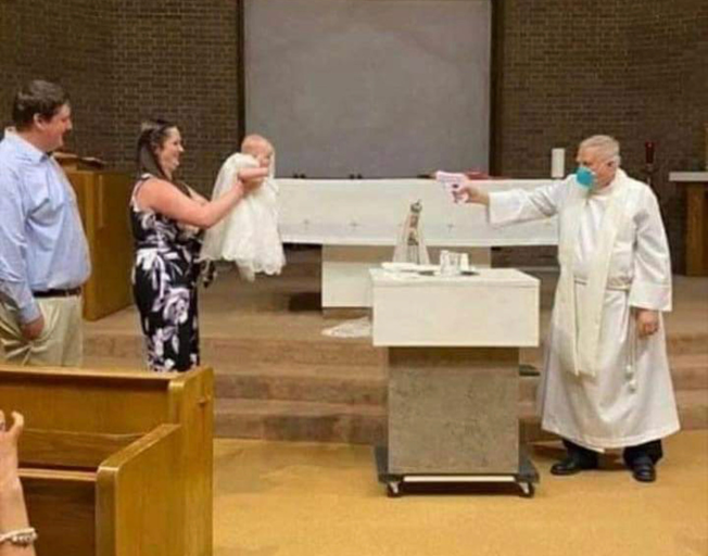 A Priest baptizing a baby from 6 feet away with a water gun