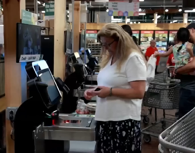 People using self-checkout at a store