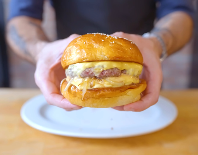 A chef holding a cheeseburger