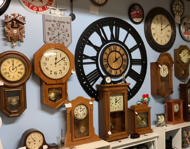 A wall with a lot of clocks hanging on it