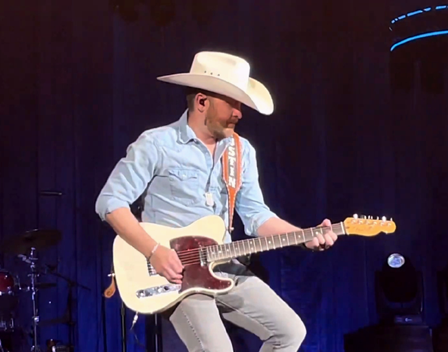 Justin Moore playing guitar on stage