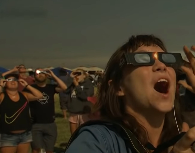 People looking at solar eclipse wearing special glasses
