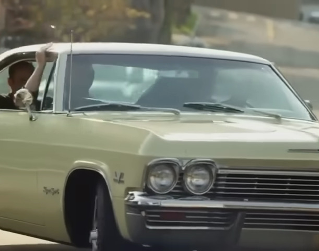 People riding in a 1965 Chevy Impala SS