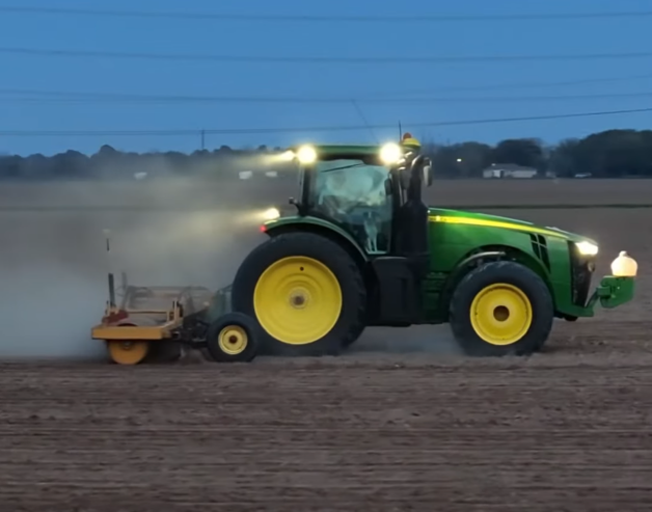 A farmer working in a tractor in the field